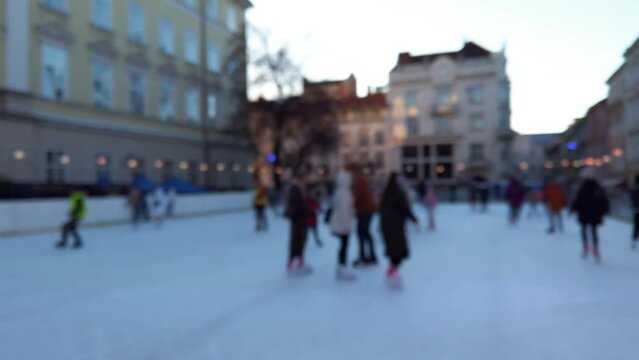 People skate on a winter rink. Out of focus.