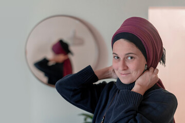 Religious Jewish woman puts a shawl on her head in front of a mirror (21)