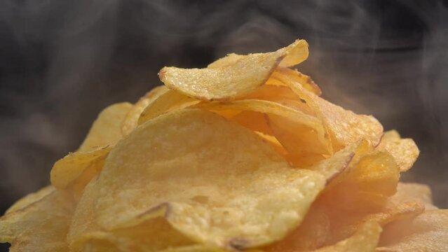 Craft crispy hot potato chips with smoke rotating on