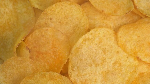 Crispy hot potato chips with smoke rotating in macro.