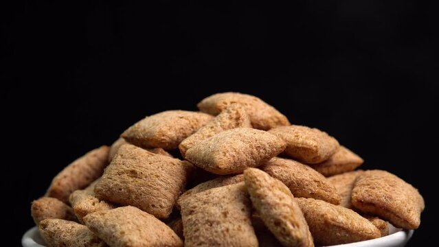 Crispy chocolate pads rotation in macro on black background.