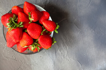 Fresh Home Grown Organic Red Strawberries in a Bowl on a Grey Slate Table with Copy Space.
