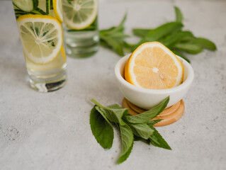 lemon and mint, ingredients for infused water on light grey concrete background. healthy food