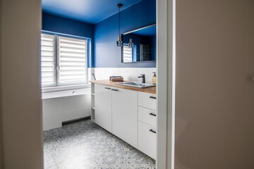 Entrance to the bathroom in a modern apartment. Bathroom door with blue walls and bathtub