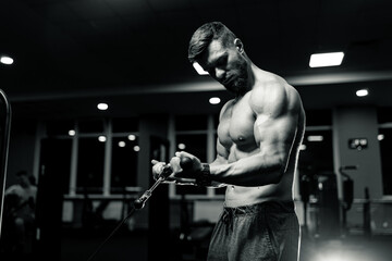Fototapeta na wymiar Strong muscular man hard working in gym. Sport athletic bodybuilder in sportswear.