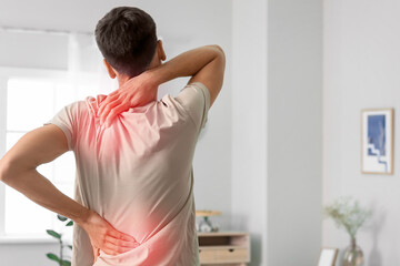 Young man with pain in spine at home
