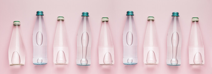Many bottles of clean water on pink background, top view