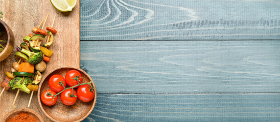 Board with tasty vegetable skewers on wooden background with space for text