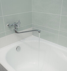 isolated faucet mixer in the bathroom on a light background. aesthetics of plumbing, disconnected water in Russia. the faucet is long, water flows from the faucet