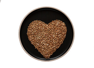 green buckwheat in the shape of a heart on a black plate