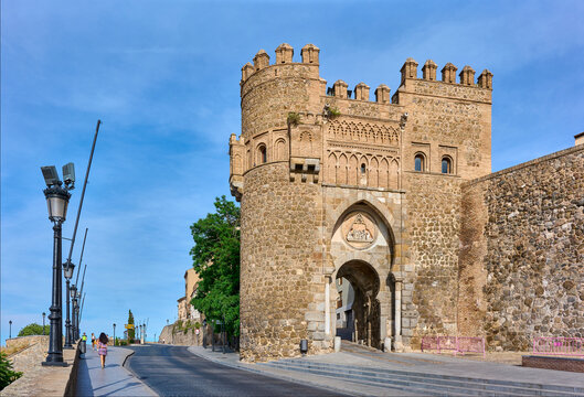 Toledo, Spain - June 30, 2022. Puerta del Sol Gate, a city gate built by the Knights Hospitaller. The medallion above the large pointed arch depicts the ordination of the Visigoth saint, Ildephonsus.
