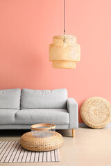 Comfortable sofa and stylish lamp near pink wall