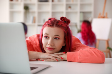 Beautiful woman with bright hair using laptop at home
