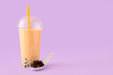 Plastic cup of tasty bubble tea on purple background - Powered by Adobe