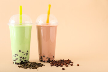 Plastic cups of different tasty bubble tea on beige background