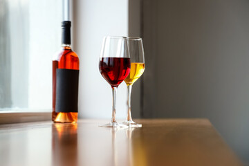 Glasses of different wines and bottle on table