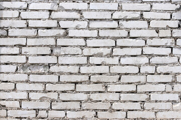 An old damaged wall made of white bricks as a background