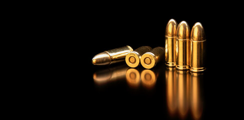 Pistol cartridges 9 mm on a smooth glossy surface with reflections. Ammunition for pistols and PCC carbines on a dark back. - obrazy, fototapety, plakaty
