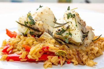 Fish dish - fried cod fillet with boiled white rice and fresh fruit salsa on white table