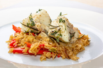 Fish dish - fried cod fillet with boiled white rice and fresh fruit salsa on white table