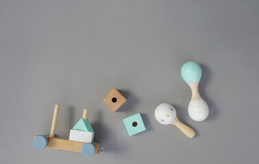 Children's handmade wooden toys of rounded, square and spherical shape, rattles on a gray background. top view.