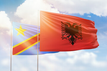 Sunny blue sky and flags of albania and dr congo