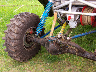 Extreme buggy ride on a dirt track. Rear suspension UTV close-up. Selective sharpness.