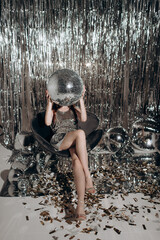 beautiful young woman with disco ball in the room
