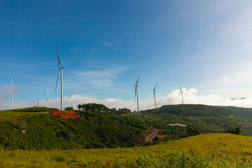 Renewable energy wind turbines windmill isolated on the beautiful blue sky, white clouds and on the tea fields in Da Lat city, Lam Dong, Viet Nam