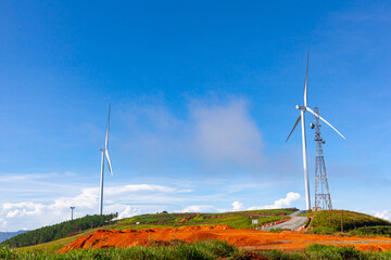 Renewable energy wind turbines windmill isolated on the beautiful blue sky, white clouds and on the tea fields in Da Lat city, Lam Dong, Viet Nam