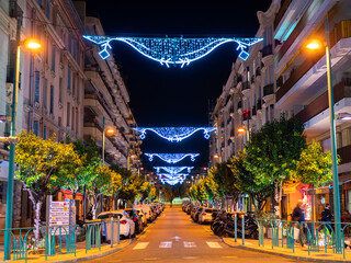 Menton, France - December 6, 2021: An illuminated and Christmas-decorated street in Menton, France,...