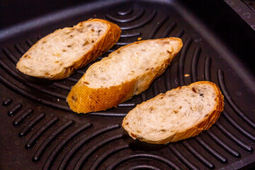 White bread toasted on an outdoor Grill on wooden table
