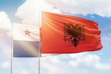 Sunny blue sky and flags of albania and panama