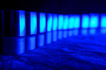 Socket wrench heads standing in a row on a soft surface in a blue light, they made of chrome vanadium. They like a small army of soldiers waiting for a next order. Background picture.