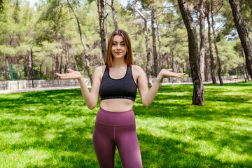 Cute caucasian woman wearing sportive clothes on city park, outdoors clueless and confused with open arms, shrugging shoulders, no idea and doubtful face.