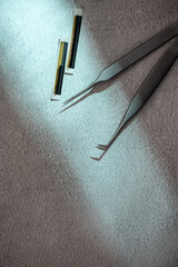 Eyelash extension tools composition: tweezers and false lashes. Flat lay, Top view