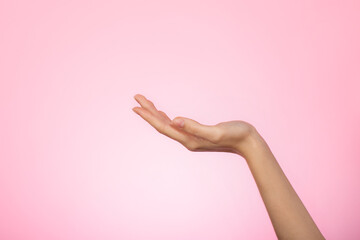 Woman's hand on pink background. Female hands ready for product placement concept. Skin and body care concept.