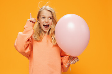cute, happy girl stands with a pink balloon in her hand and screams loudly