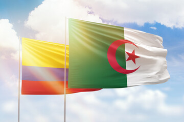 Sunny blue sky and flags of algeria and colombia