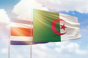 Sunny blue sky and flags of algeria and costa rica