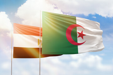 Sunny blue sky and flags of algeria and egypt