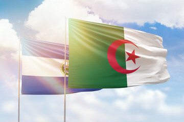Sunny blue sky and flags of algeria and el salvador