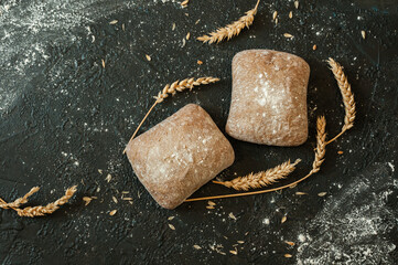 Two rolls of ciabatta on a black background with copy space. Top view, flat lay