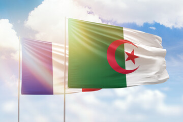 Sunny blue sky and flags of algeria and france