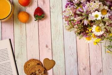 Juice, apricots and book on colorful table, copy space