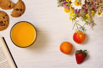Breakfast on wooden table, flowers and book, copy space