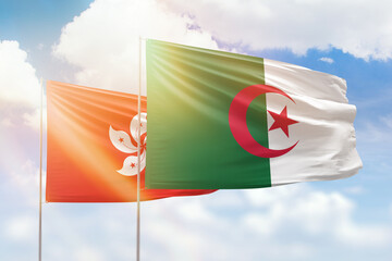 Sunny blue sky and flags of algeria and hong kong