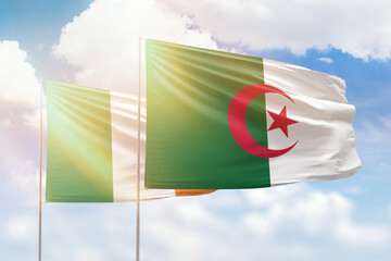 Sunny blue sky and flags of algeria and ireland