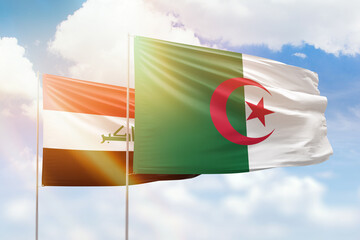 Sunny blue sky and flags of algeria and iraq
