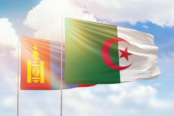 Sunny blue sky and flags of algeria and mongolia